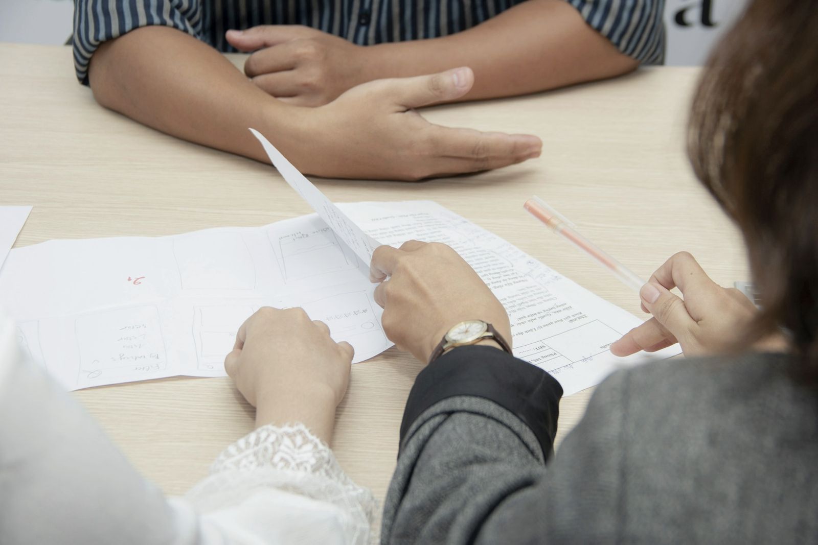 Two people reviewing an agreement across a table